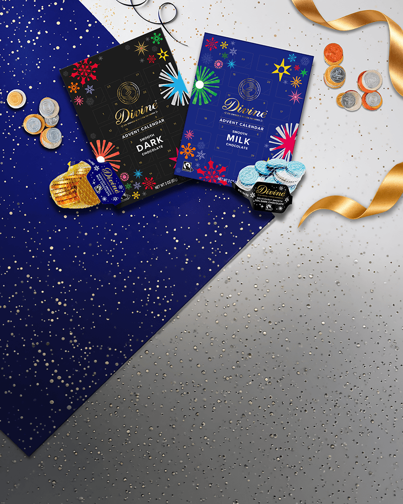 Divine Chocolate dark and milk chocolate Advent calendars displayed with assorted foil-wrapped chocolate coins, gold satin ribbons, and sparkling confetti on a festive blue and silver background.