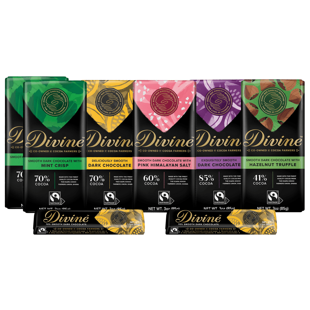 Six Divine brand chocolate bars in assorted flavors lined up on a white background, with two additional wrapped bars in front. The packaging features colorful flavor-specific graphics in green, yellow, pink, purple, and red, with black lower sections and gold Divine branding.